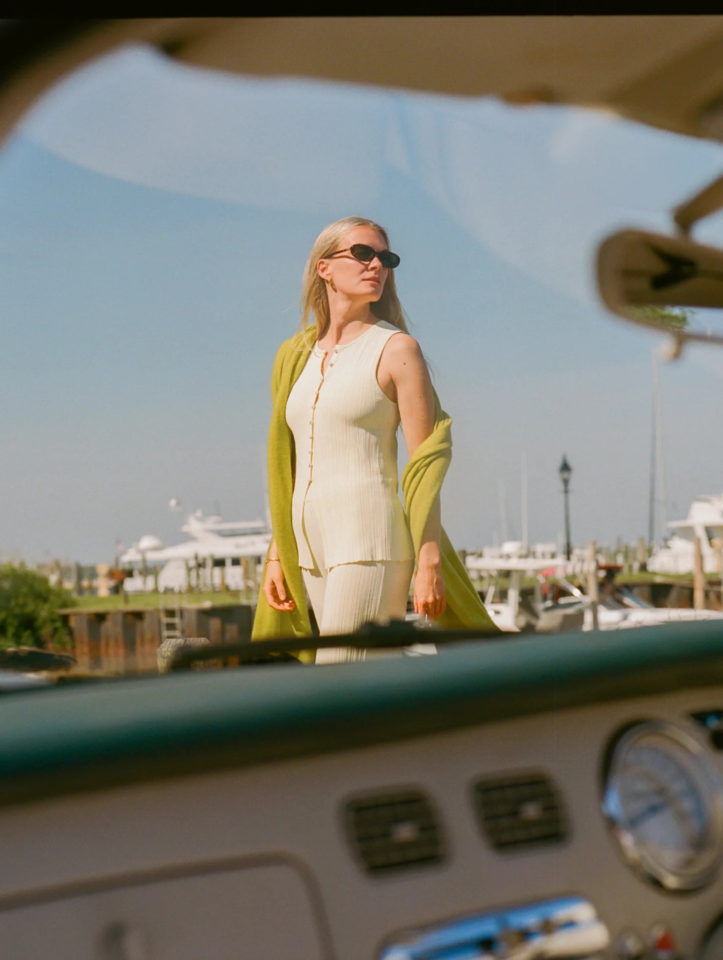 Woman standing inside a vehicle with a marina view through the windshield