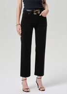 Person wearing black pants with a gold belt on a white background