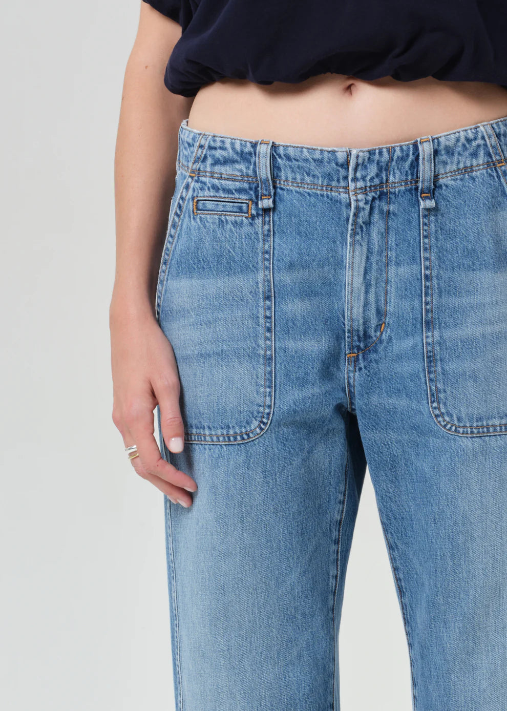 Close-up of blue jeans worn by a person on a plain background