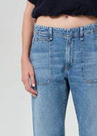 Close-up of blue jeans worn by a person on a plain background
