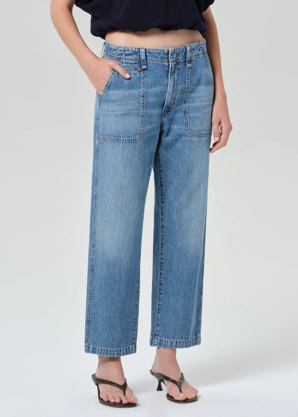 Person wearing blue jeans on a white background