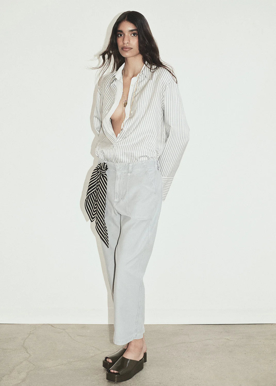 Woman wearing a light gray suit with a white shirt against a white background