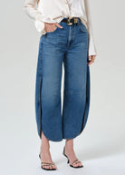 Person wearing blue wide-leg jeans on a plain background