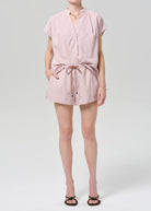 Person wearing a pink striped romper on a white background