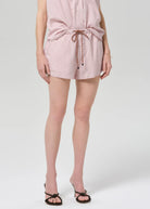 Person wearing a pink striped romper on a white background