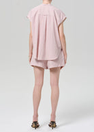 Person wearing a pink striped outfit on a white background