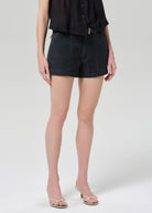 Person wearing black shorts on a plain background