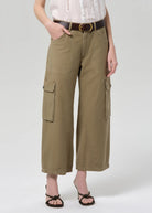 Person wearing olive green cargo pants on a white background