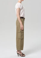 Person wearing a white top and beige cargo pants on a plain background