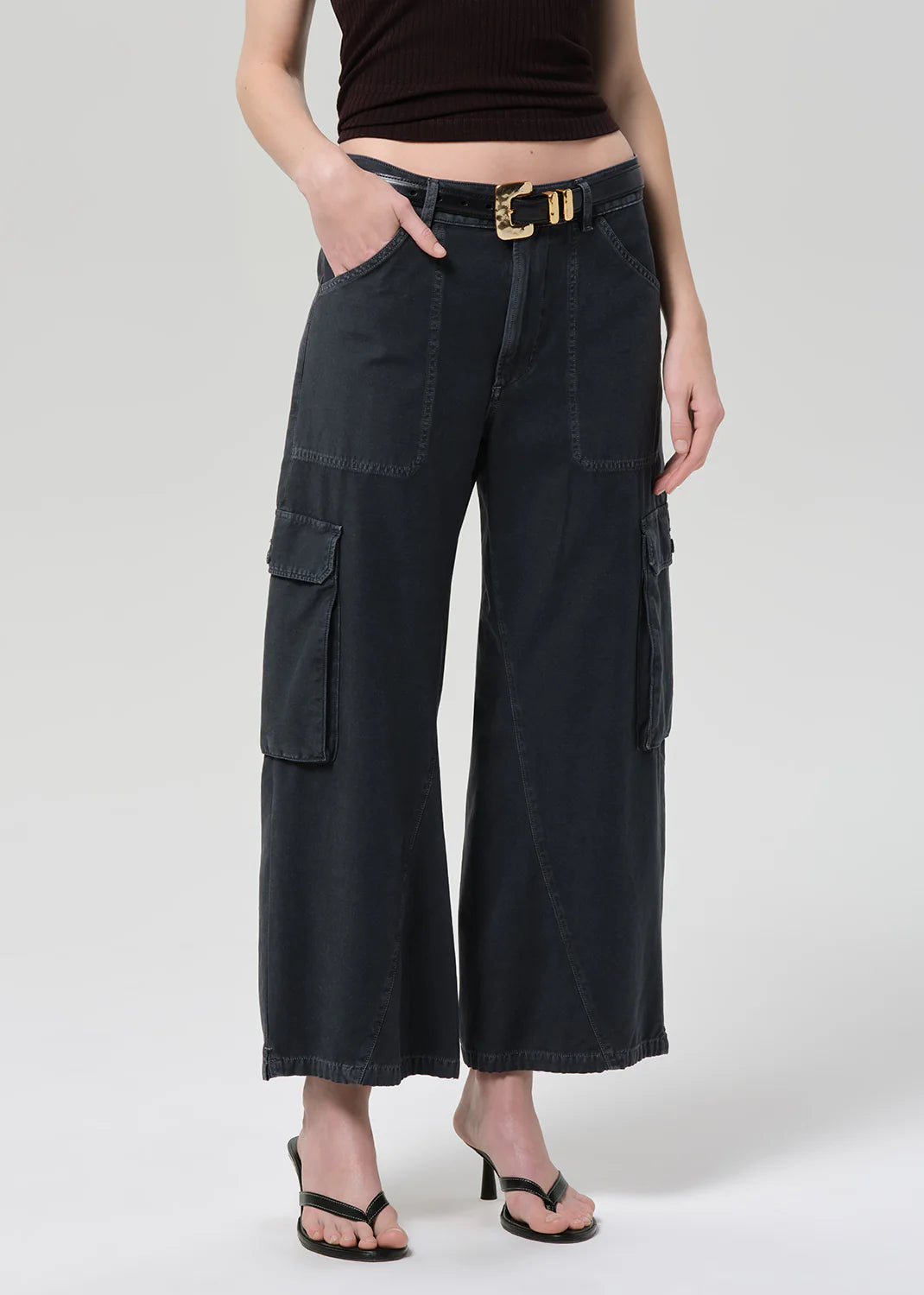 Person wearing black wide-leg cargo pants on a white background