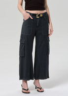 Person wearing black wide-leg cargo pants on a white background