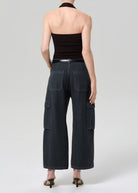 Person wearing black halter top and wide-leg cargo pants on a plain background