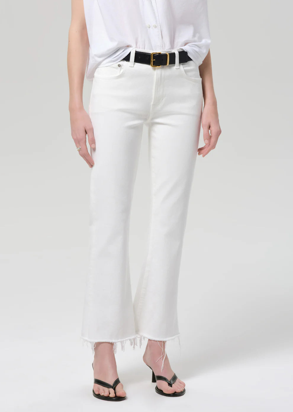 Person wearing white pants and a white shirt on a plain background