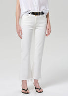 Person wearing white pants and a white shirt on a plain background