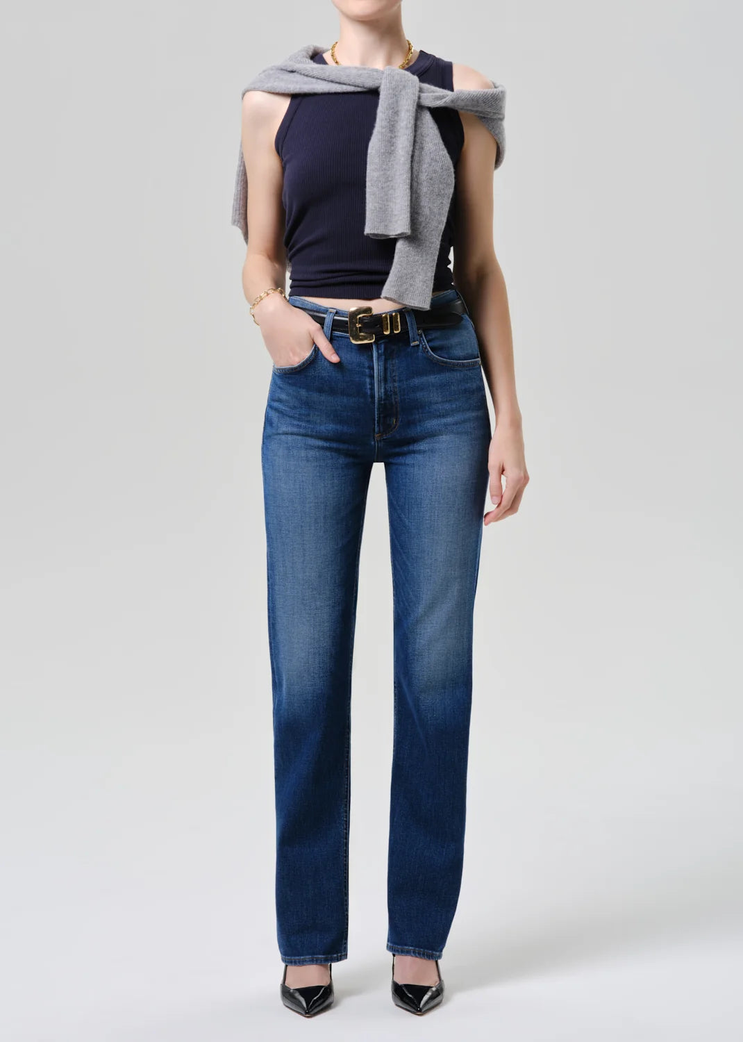 Person wearing blue jeans with a plain background