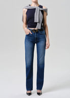 Person wearing blue jeans with a plain background