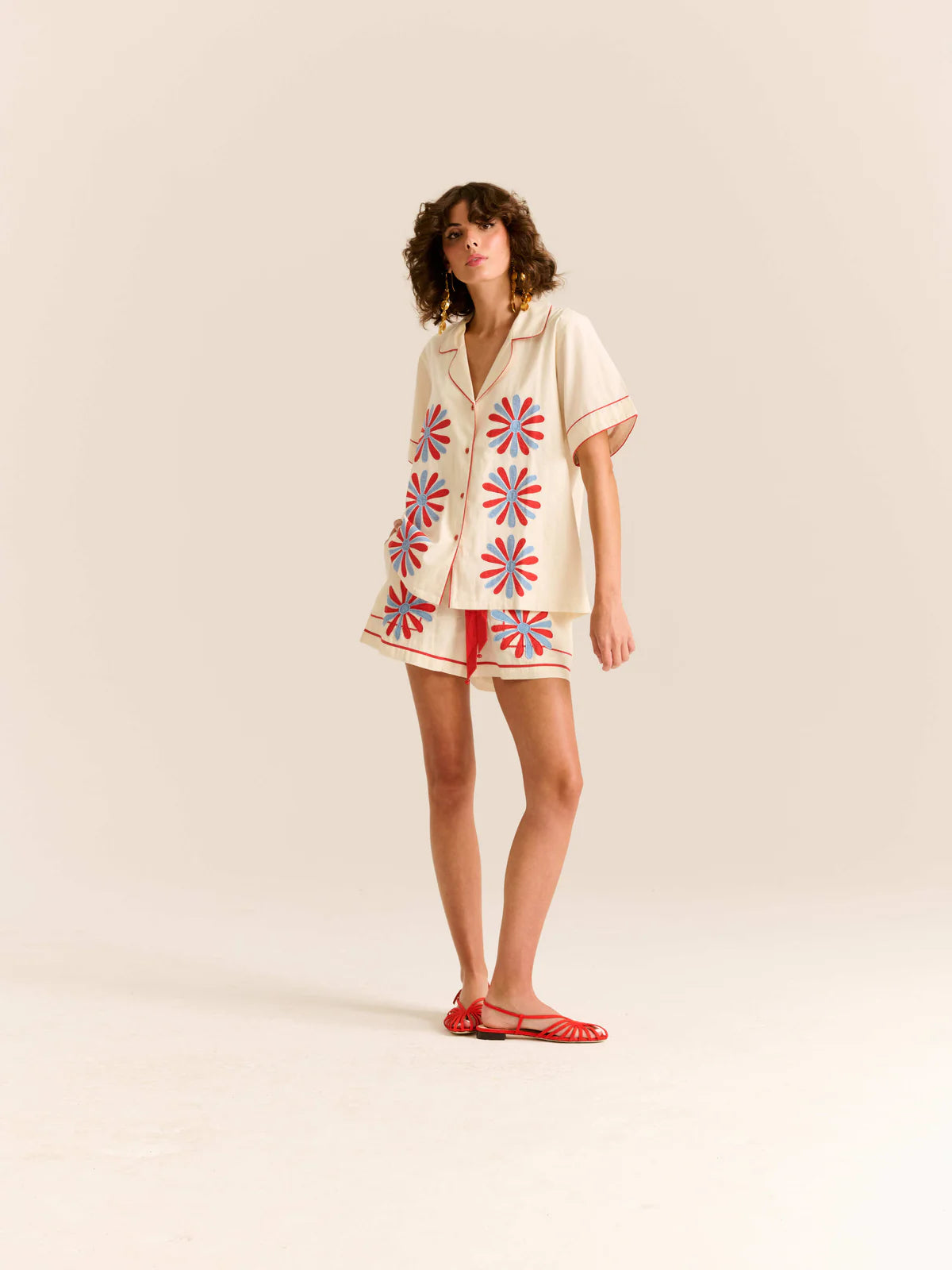 Beige shirt with red and blue floral patterns on a white background