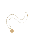 Gold necklace with a round pendant on a white background