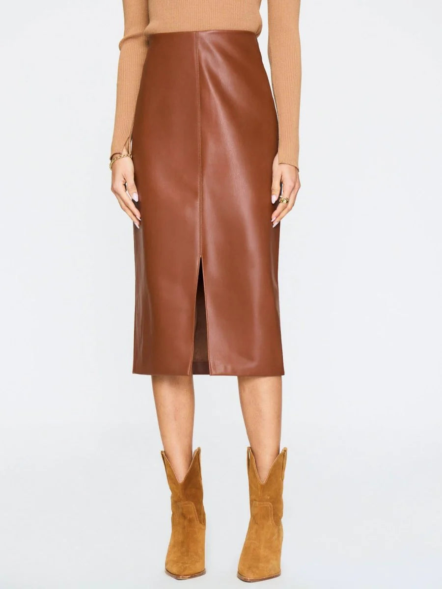 Person wearing a brown leather skirt and matching boots on a white background