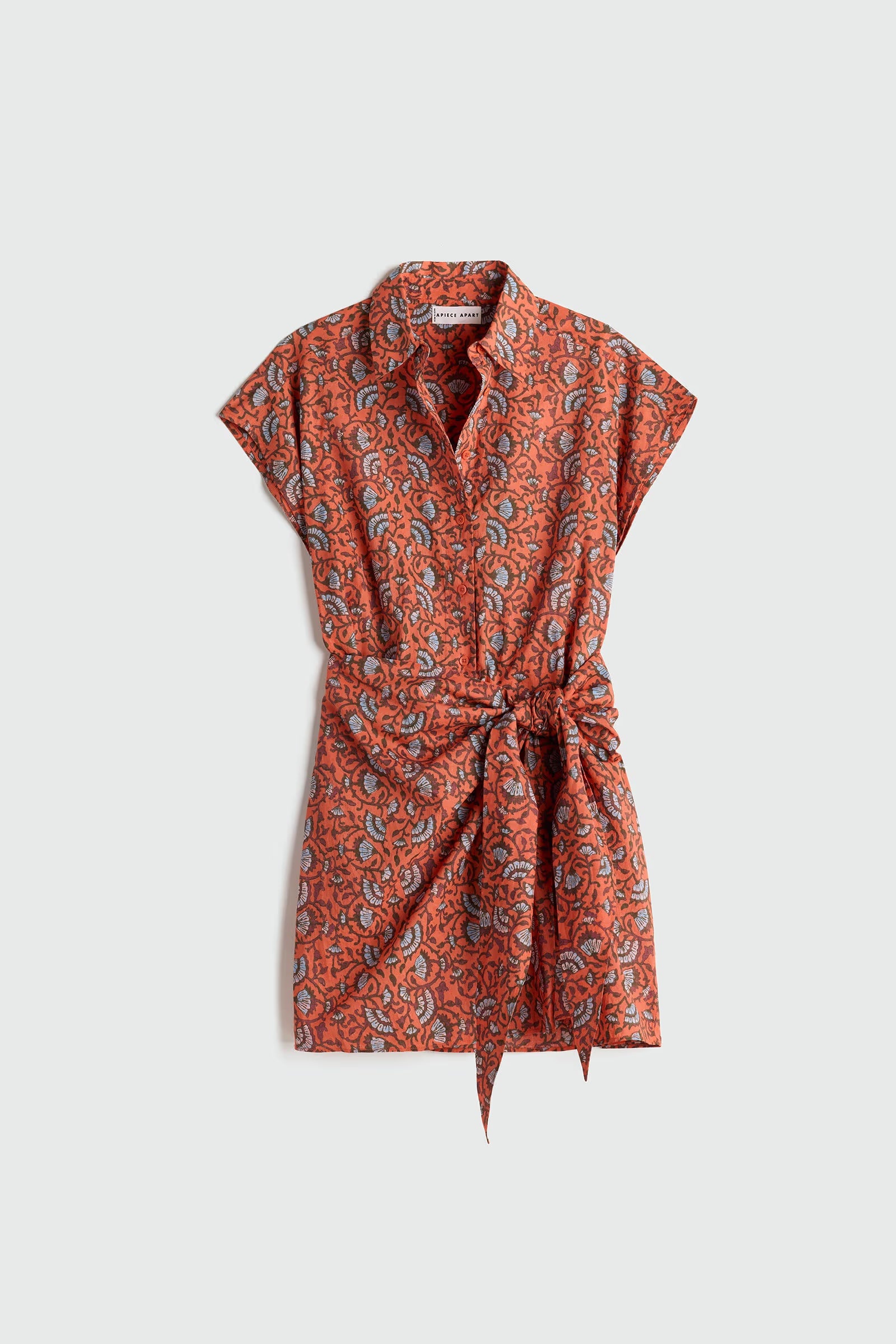 Orange patterned dress with a belt on a light gray background