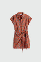 Orange patterned dress with a belt on a light gray background