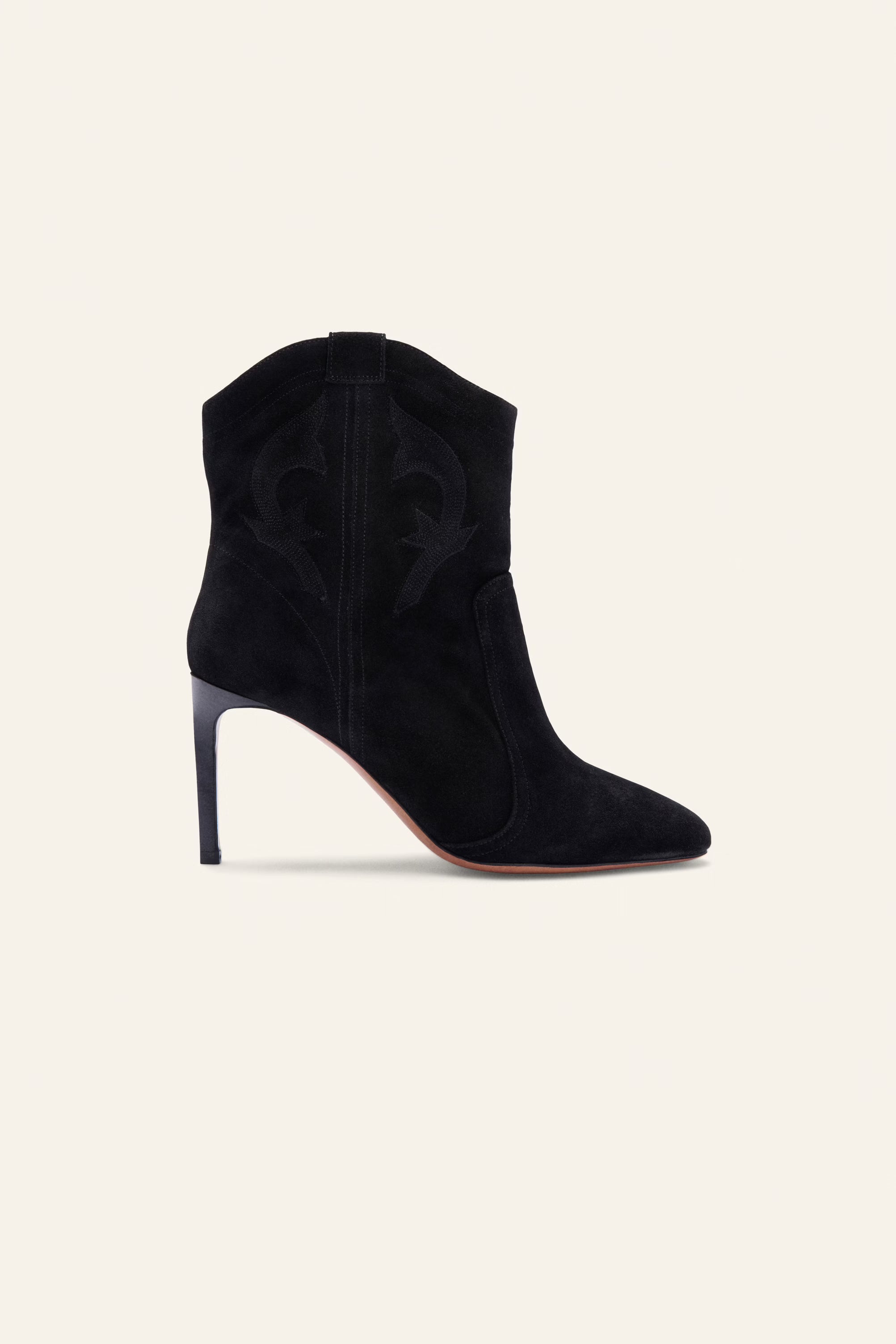 Black high-heeled ankle boot on a beige background