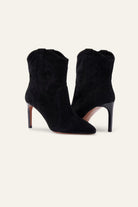 Black suede ankle boots on a white background