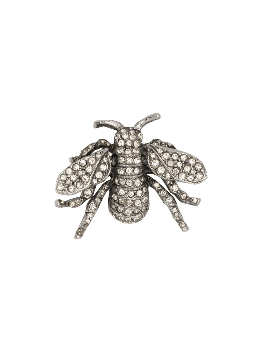 Silver bee-shaped brooch with gemstones on a white background
