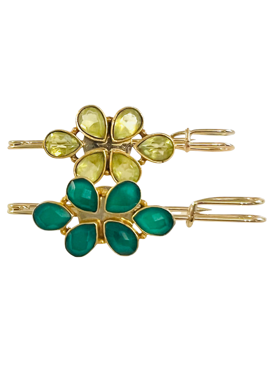 Gold hair clips with green and yellow gemstones on a white background