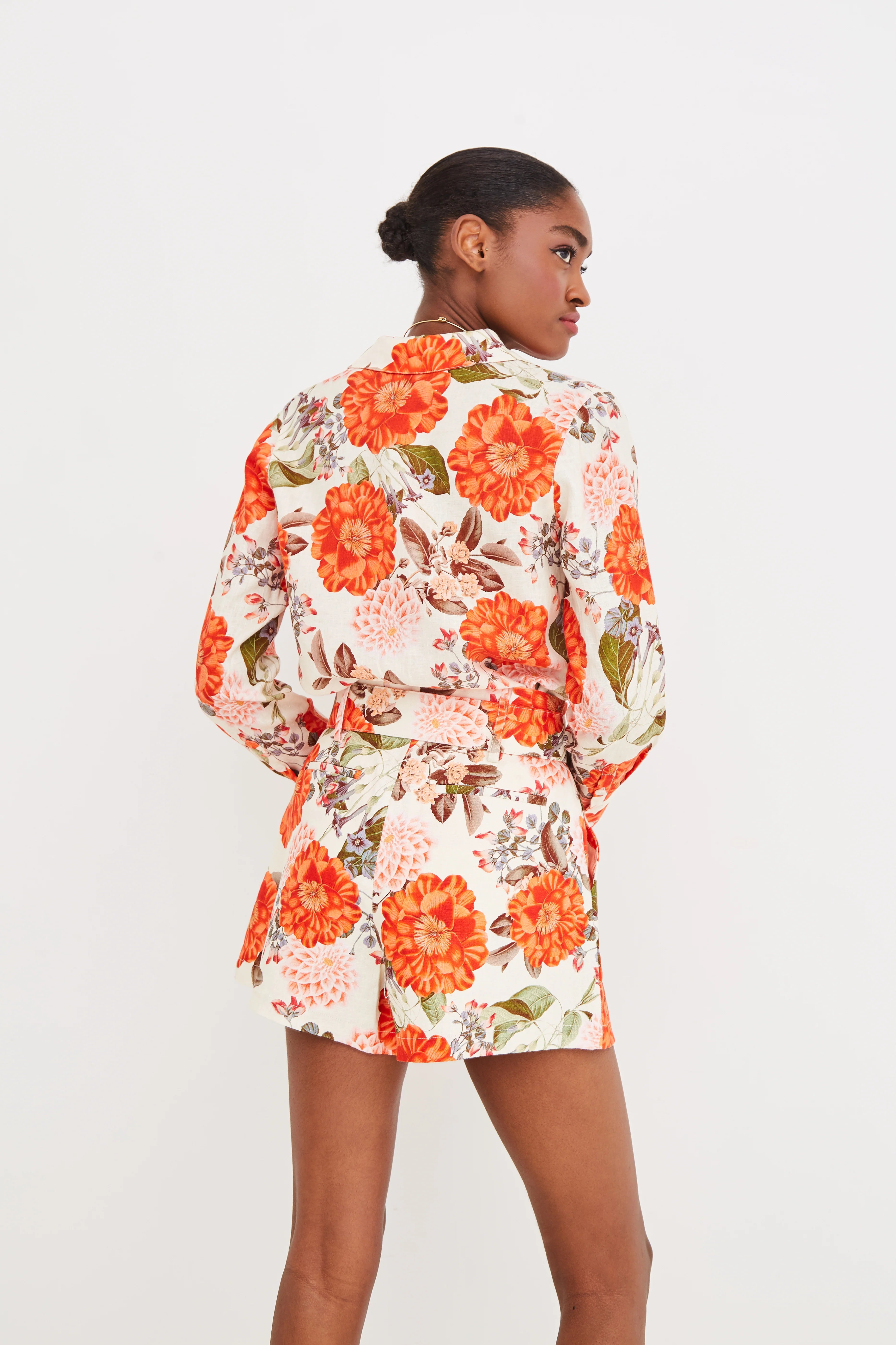 Woman wearing a floral dress with orange flowers on a white background
