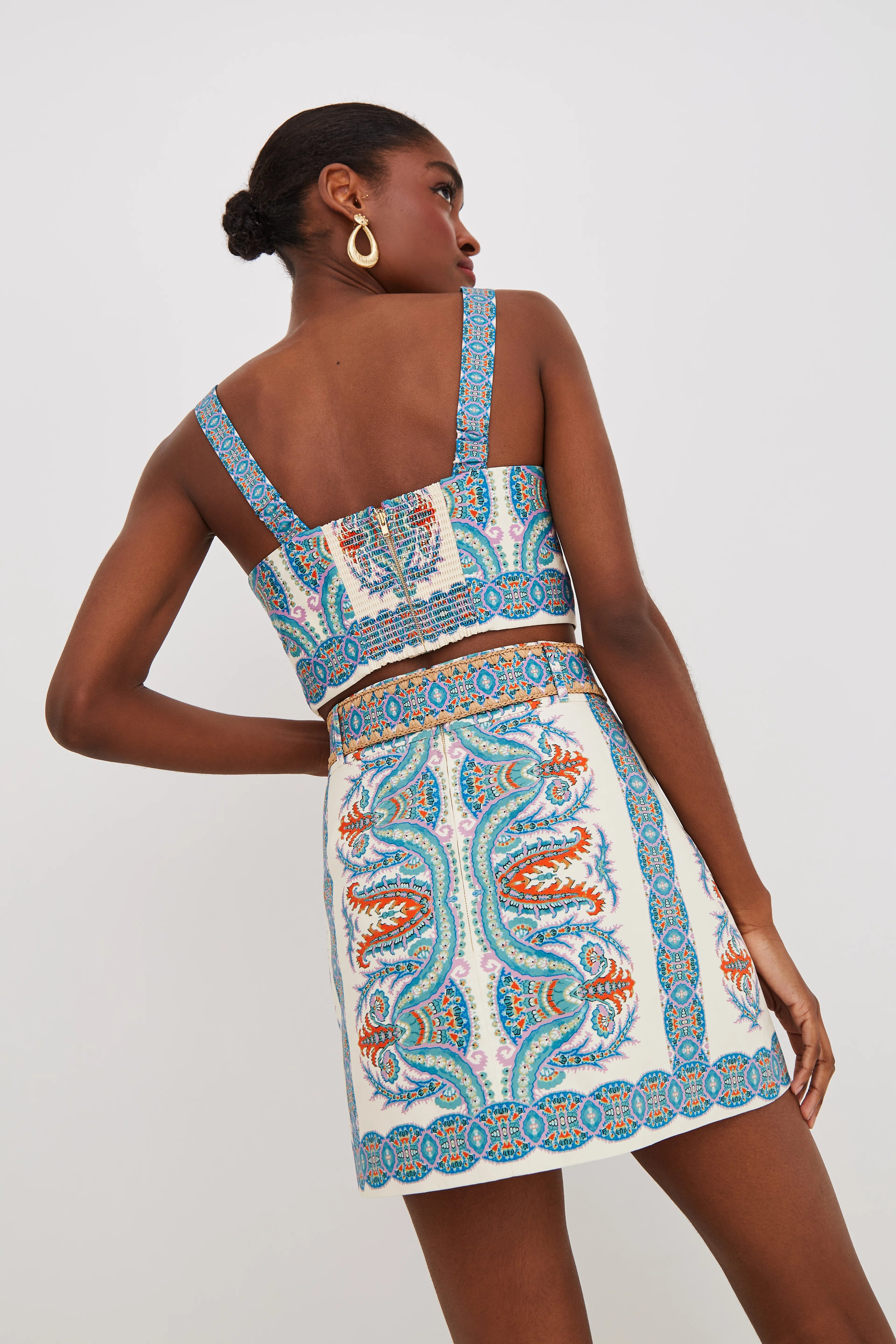 Woman wearing a patterned two-piece outfit on a white background