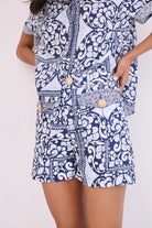 Navy and white patterned dress with gold buttons on a plain background