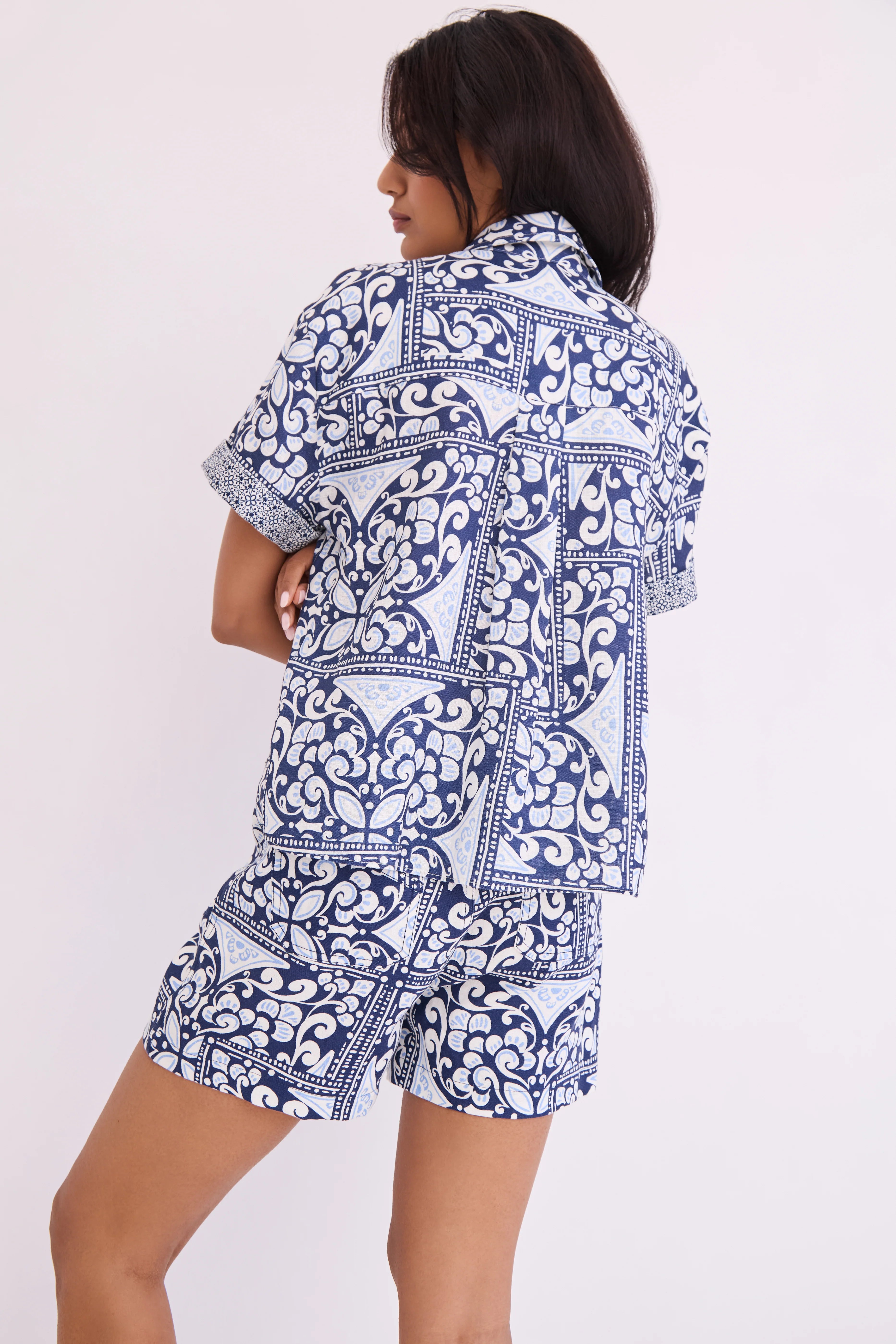 Woman wearing a blue and white patterned outfit on a white background