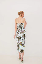 Woman wearing a floral dress against a plain background