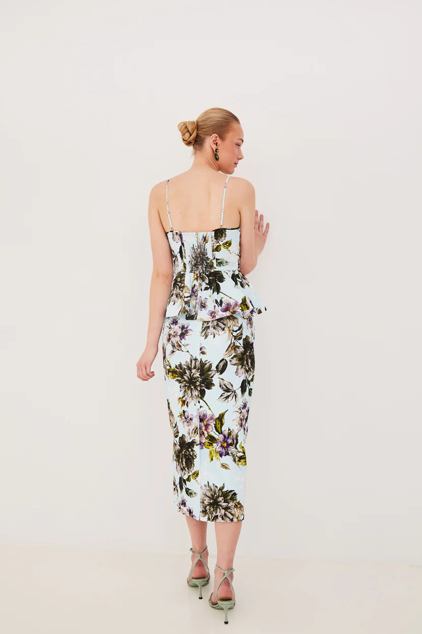 Woman wearing a floral dress against a plain background