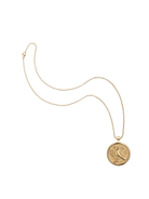 Gold necklace with a circular pendant on a white background