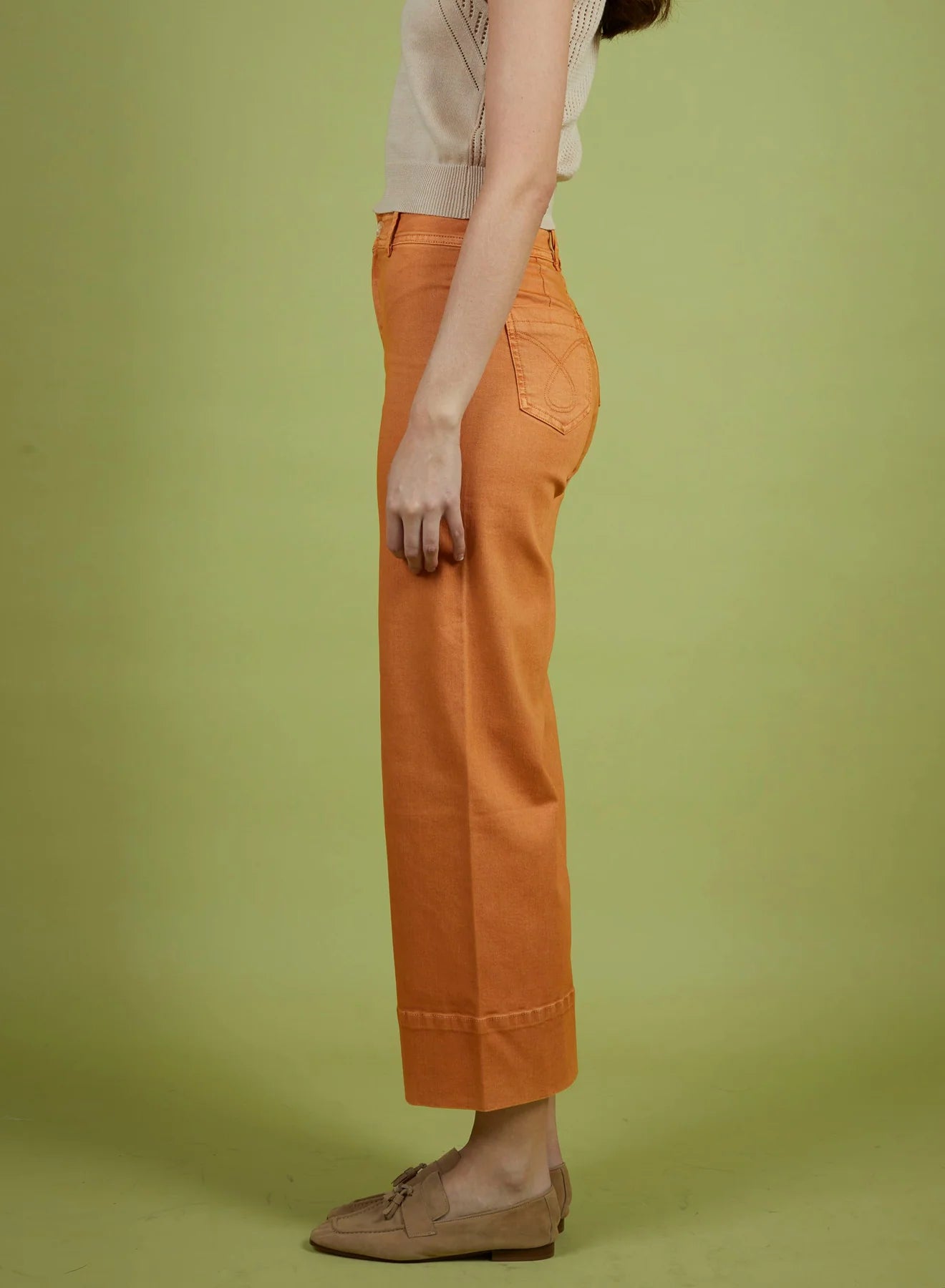 Person wearing orange pants on a green background