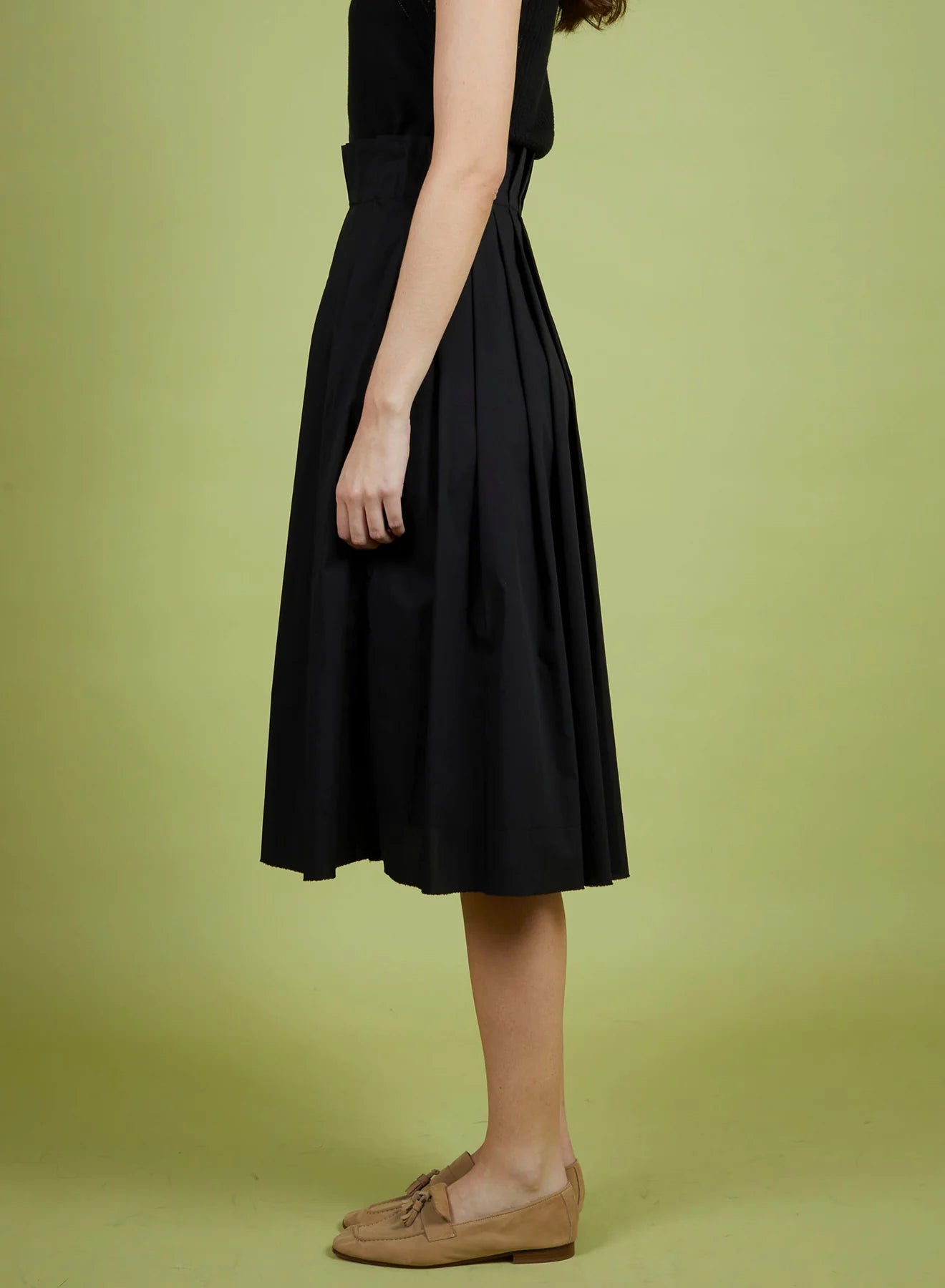 Person wearing a black dress on a green background