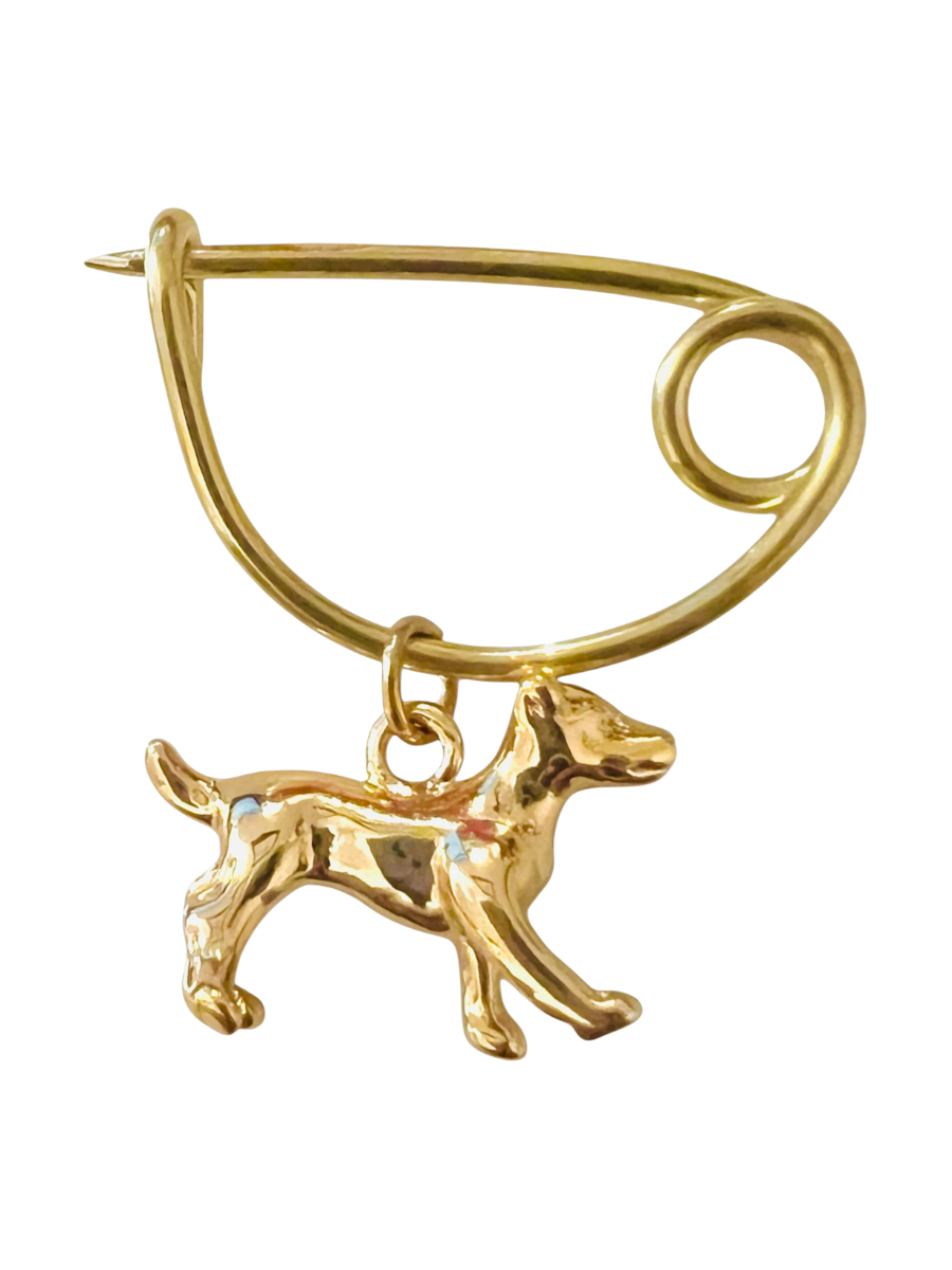 Gold brooch with a dog charm on a white background