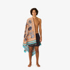 Man holding a patterned towel on a white background