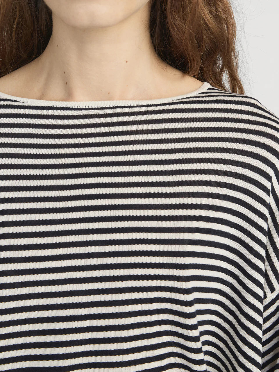 Close-up of a person wearing a black and white striped shirt.