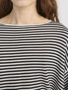 Close-up of a person wearing a black and white striped shirt.