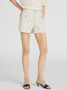 Person wearing white striped shorts on a plain background
