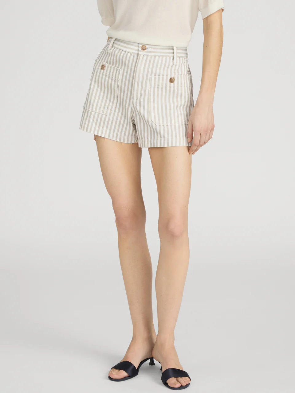 Person wearing white shorts with black stripes on a light gray background