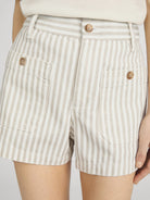 Beige and white striped shorts with button details on a plain background