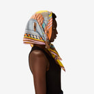 Woman wearing a colorful patterned headscarf on a white background