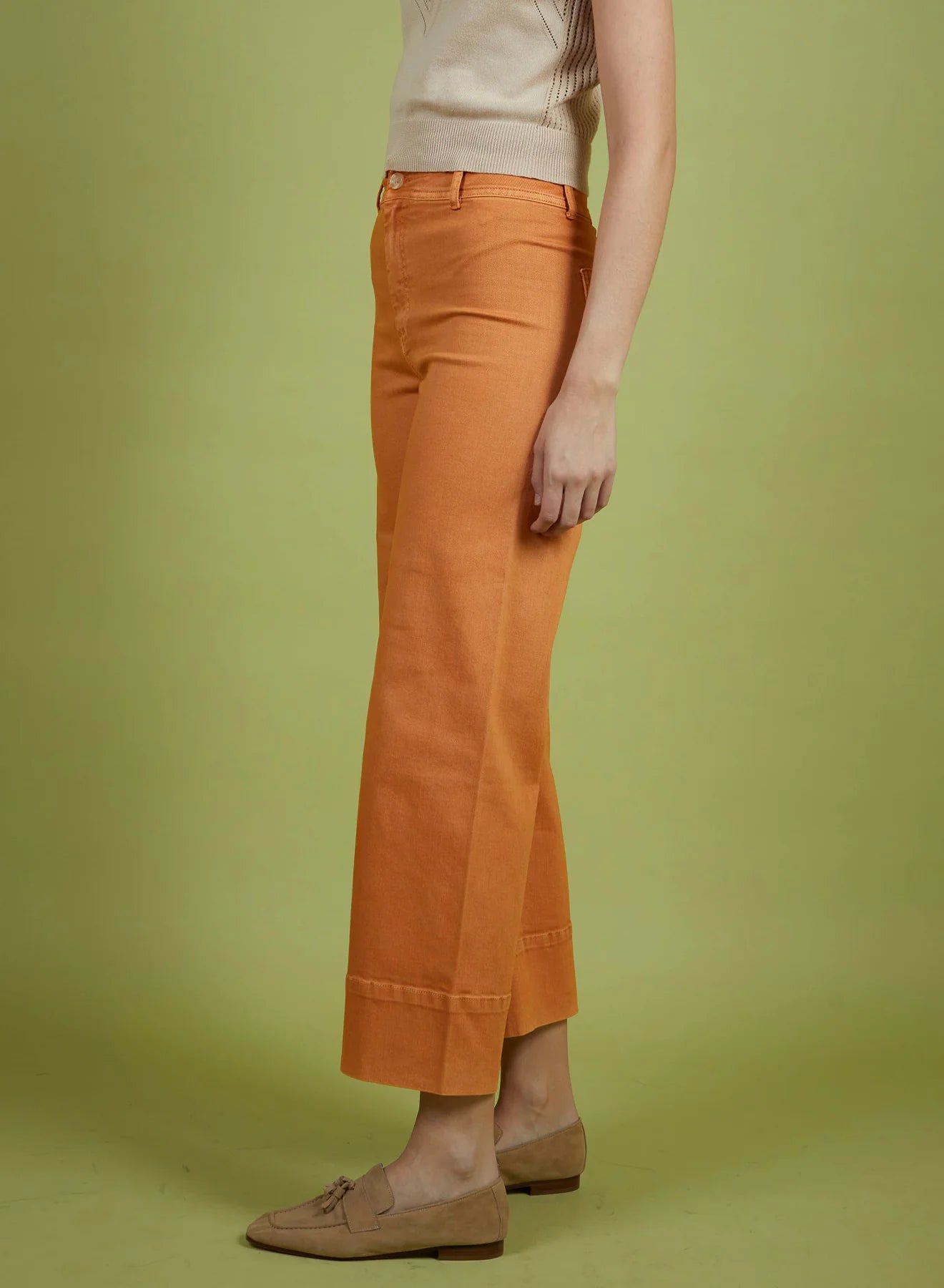 Person wearing orange pants on a green background