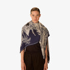 Woman wearing a patterned scarf on a white background