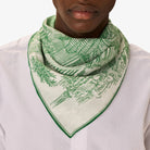 Person wearing a green and white patterned scarf on a white background