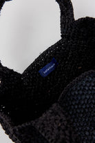 Black knitted hat with a brand label on a white background